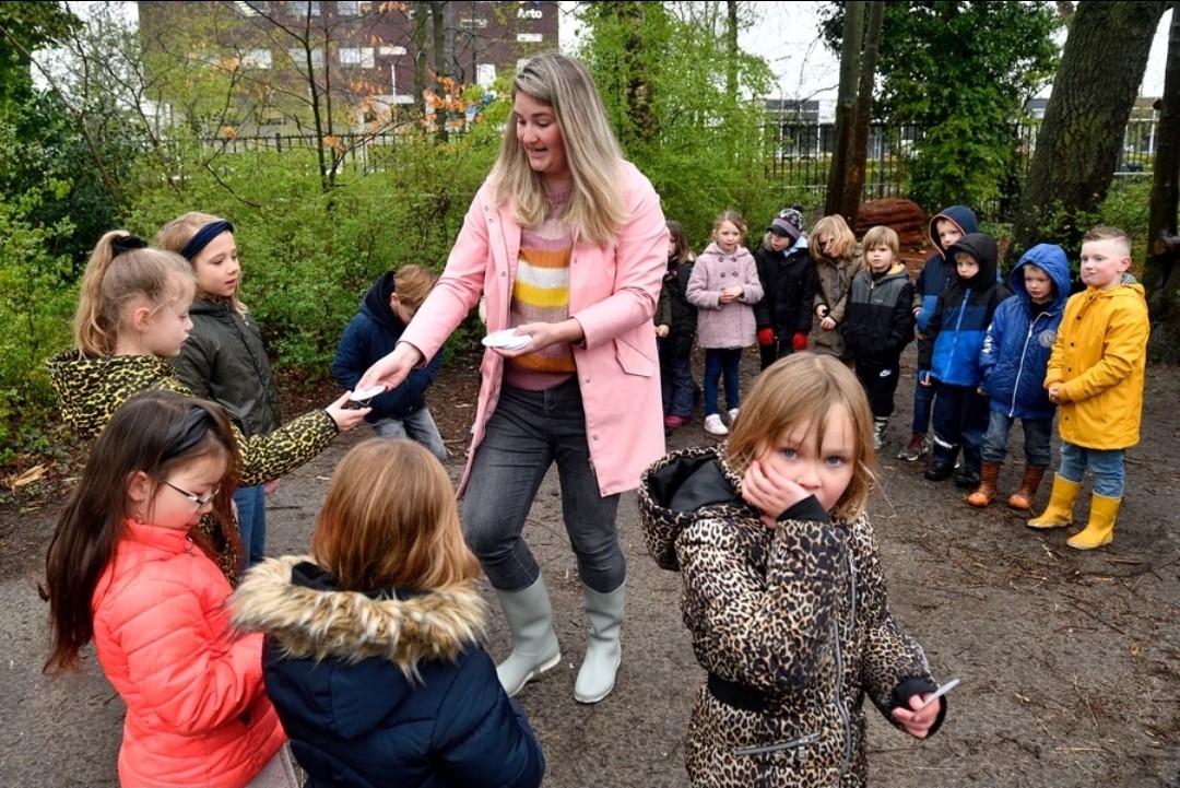 Linda met kinderen op het schoolplein